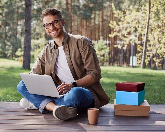 Für jeden das Richtige! Mann mit Laptop auf einer Holzterrasse im Wald