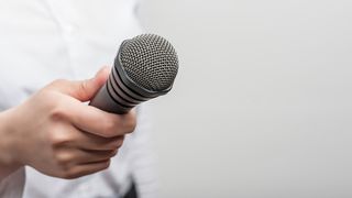 Interviews mit den Azubis der IKK gesund plus Eine Frauenhand hält ein Mikrofon in Richtung Kamera