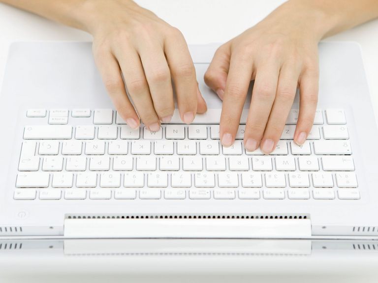 Frau tippt auf Laptoptastatur