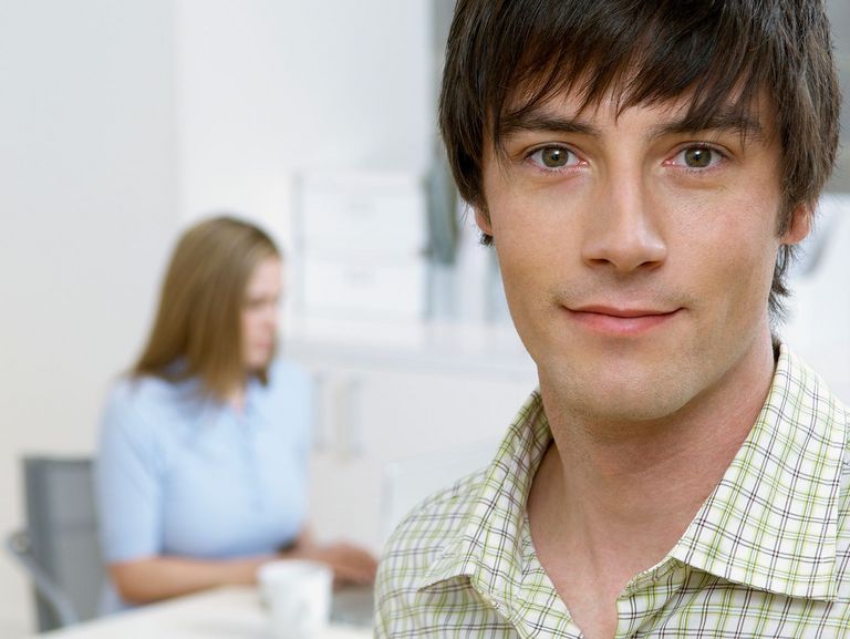 junger Büromitarbeiter schaut in die Kamera