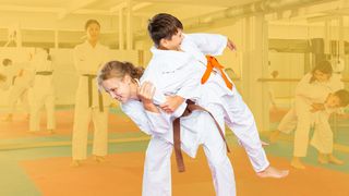 Trainerin der Selbstverteidigung mit ihren Schülern auf der Matte