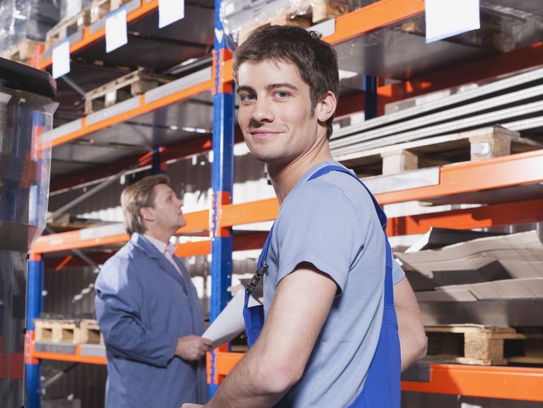 Junger lächelnder Mann arbeitet im Lager