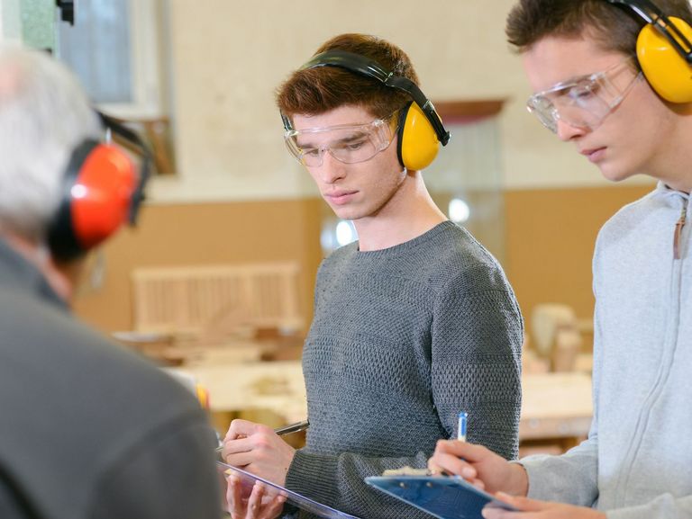 Auszubildende Tischler machen sich Notizen