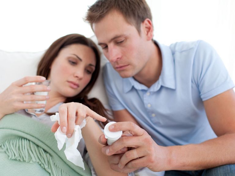 Mann und Frau schauen auf das Haltbarkeitsdatum eines Medikaments