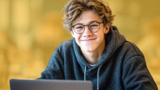 Schulabschluss Schüler mit Brille vor einem Laptop sitzend