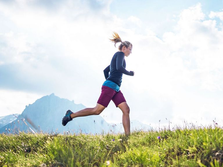 Sportliche Frau beim Trailrunning in den Bergen