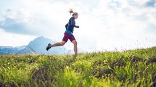 Sportliche Frau beim Trailrunning in den Bergen