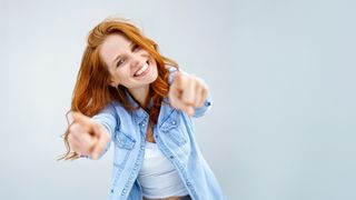 Vorteile im Überblick Frau mit langen Haaren zeigt mit beiden Händen auf den Betrachter