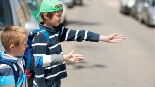 Sicherer Schulweg für Kinder Kleine Schulkinder wollen eine Straße überqueren