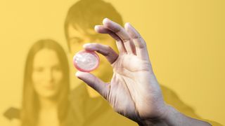 Verhütung Teenager-Paar und im Vordergrund ein Kondom in der Hand