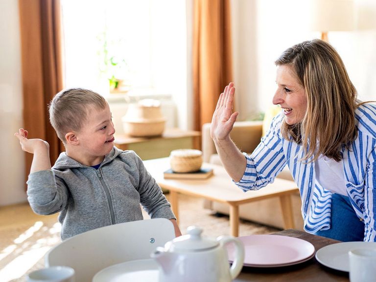 Pflegerin kümmert sich mit viel Freude um ein behindertes Kind 