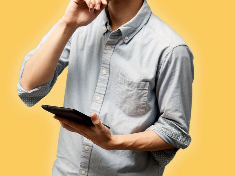 Junger Mann mit Tablet und nachdenklicher Pose