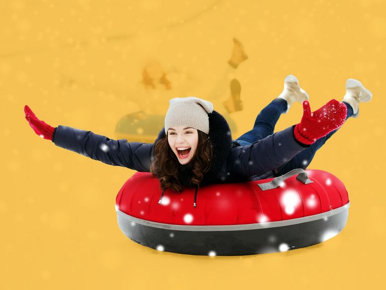 Junge Frau bäuchlings auf einem Rodelreifen