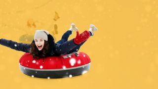 Junge Frau bäuchlings auf einem Rodelreifen