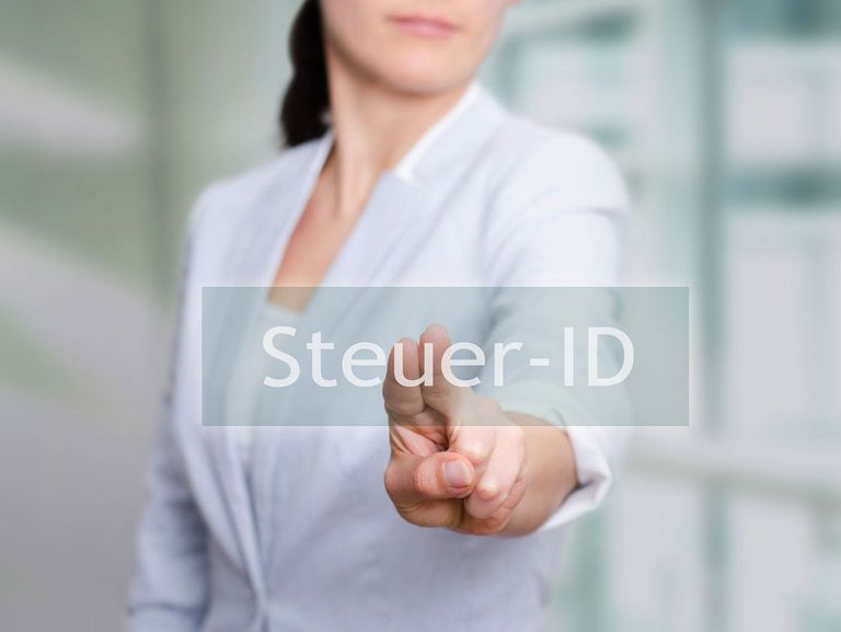 Frau in einem weißen Jacke drückt auf eine transparente Schaltfläche im Vordergrund mit der Aufschrift "Steuer-ID"
