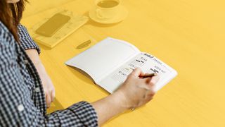 Bullet Journal Jugendliche schreibt etwas in ein Bullet Journal