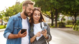 Urlaub in der Großstadt Pärchen navigiert mit dem Smartphone durch eine Großstadt