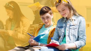 Gruppe von Schülern mit Notizbüchern auf dem Schulhof