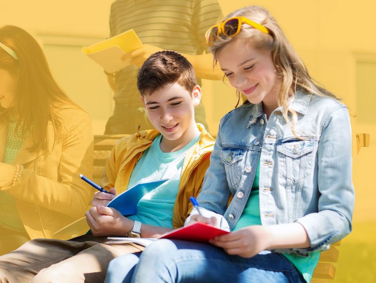 Gruppe von Schülern mit Notizbüchern auf dem Schulhof