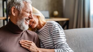 Gemeinsame Zeit genießen Paar sitzt lachend auf der Couch