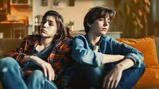 Stressfaktoren und Ängste Zwei deprimiert und lustlos schauende Jugendliche sitzen auf einem Sofa