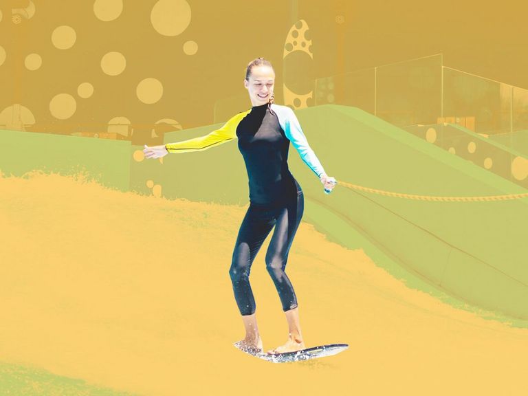 Junge Frau übt das Indoor-Surfen mit Sicherungsleine
