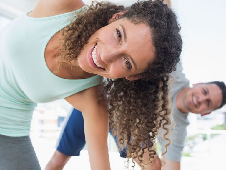 Sporttreibende Frau und ein Mann schauen in die Kamera