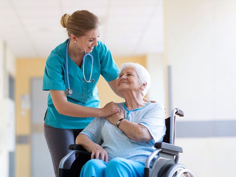 Stationspflegerin betreut eine Pflegebedürftige im Rollstuhl
