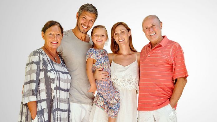 3-Generationen-Familie in Sommerkleidung vor einem grauen Hintergrund