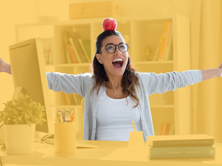 Jugendliche am Schreibtisch mit einem Apfel auf dem Kopf