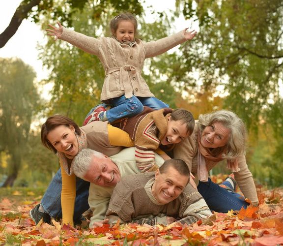 Herbstmeisterschaften Familie liegt aufeinander gestapelt im Herbstlaub