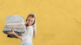 Blonde Jugendliche trägt einen Stapel Kissen