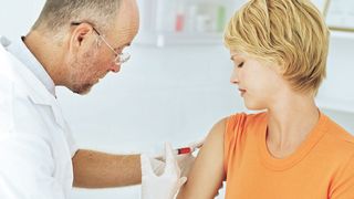 Frau erhält vom Arzt eine Impfung