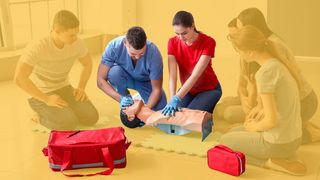 Teilnehmer beim Erste-Hilfe-Kurs an einer Beatmungspuppe