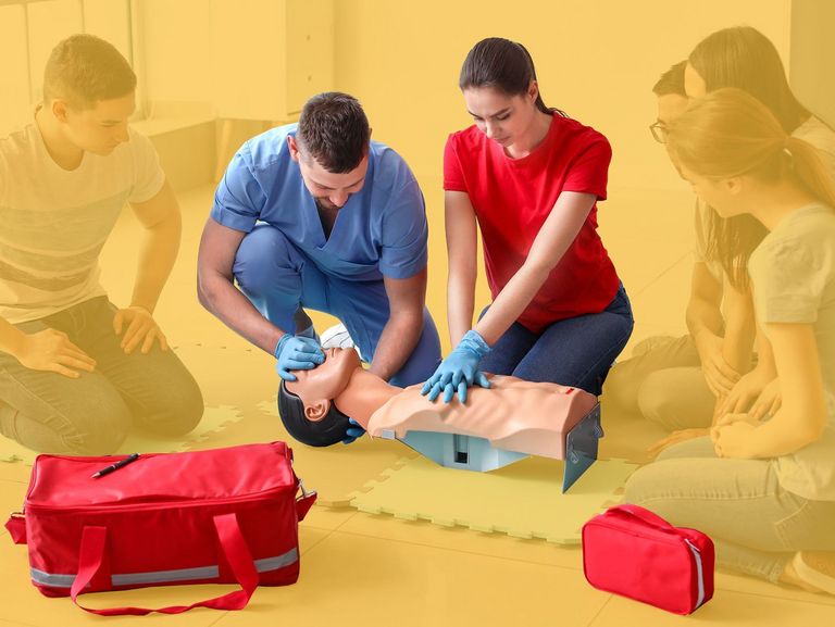 Teilnehmer beim Erste-Hilfe-Kurs an einer Beatmungspuppe