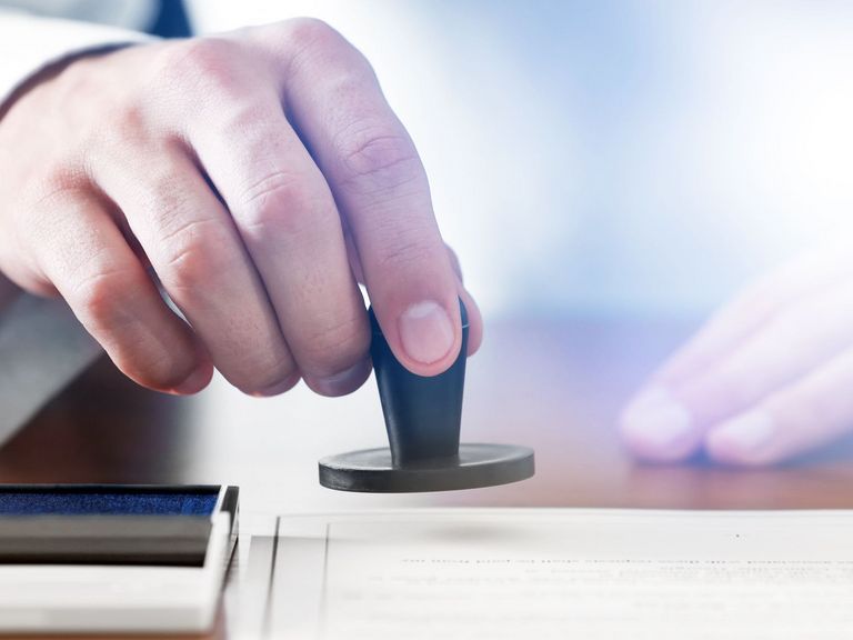 Ein Mann nutzt einen runden Stempel