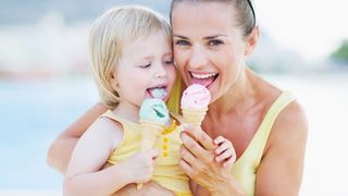 Glückliche Mutter ist mit ihrem Kind Eiscreme