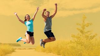 Zwei Jugendliche springen auf einem Strandzugang in die Luft	