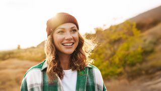 Herbstspaziergang Frau in Herbstkleidung und Mütze macht einen Spaziergang