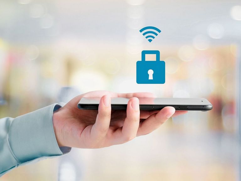 In einer Hand liegt ein Smartphone und darüber schwebt ein Sicherheitsschlosssymbol