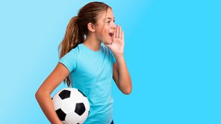 Mädchen mit Fußball unter einem Arm ruft etwas