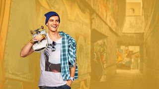 Skateboarding Junger Skater steht mit Skateboard an einer Hauswand