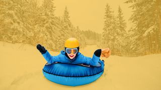 Airboarding Junge mit gelbem Helm auf einem blauen Airboard