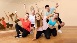 Sport & Bewegung Gruppe Jugendliche im Sportstudio in Formation vor Spiegelflächen