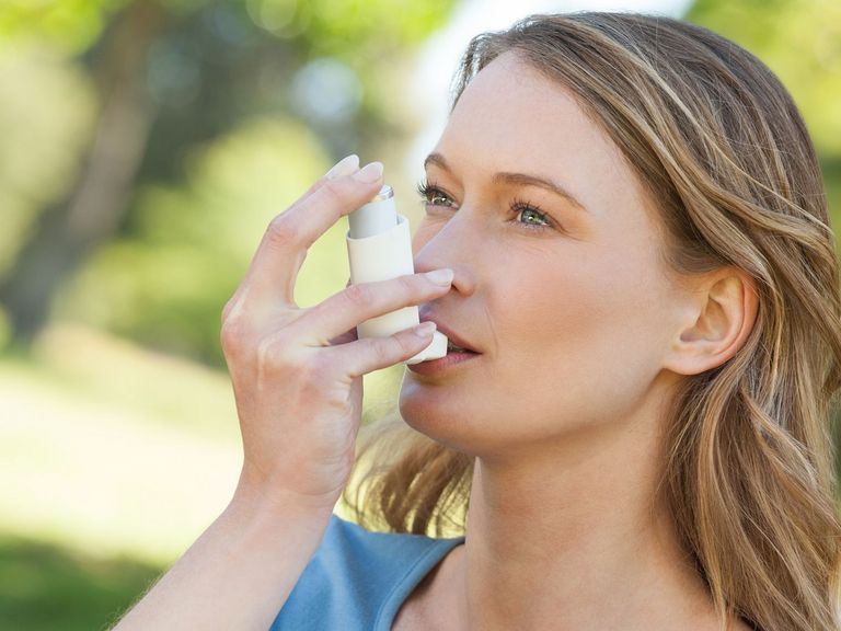 Frau nutzt ein Asthma-Spray
