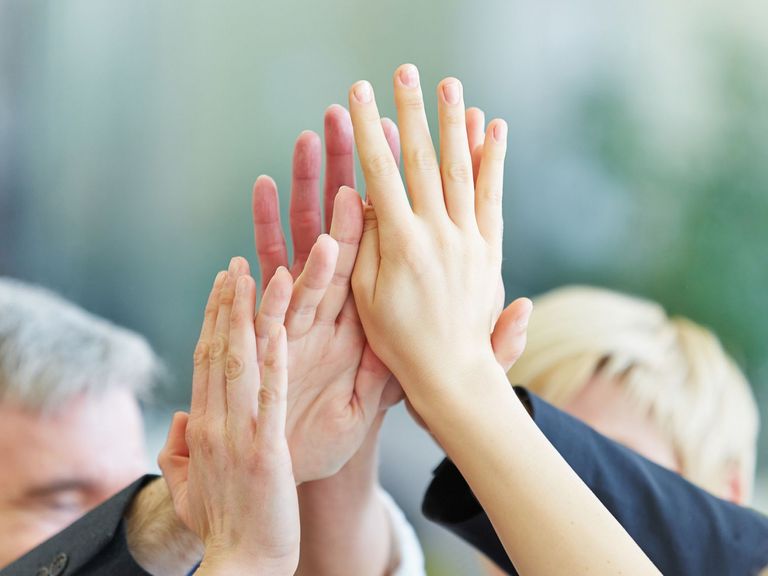 Mitglieder einer Selbsthilfegruppe schlagen ihre Hände aneinander