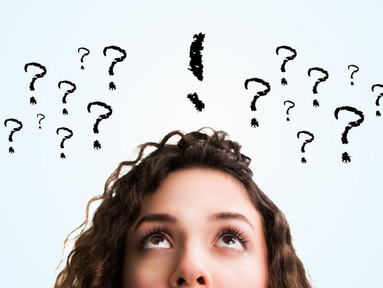 Frau mit vielen Fragezeichen über dem Kopf