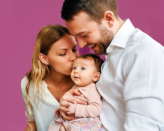 Junge Eltern Glückliche, junge Eltern mit ihrem Baby auf dem Arm