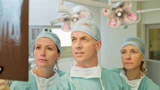 Drei Ärzte schauen auf ein Röntgenbild