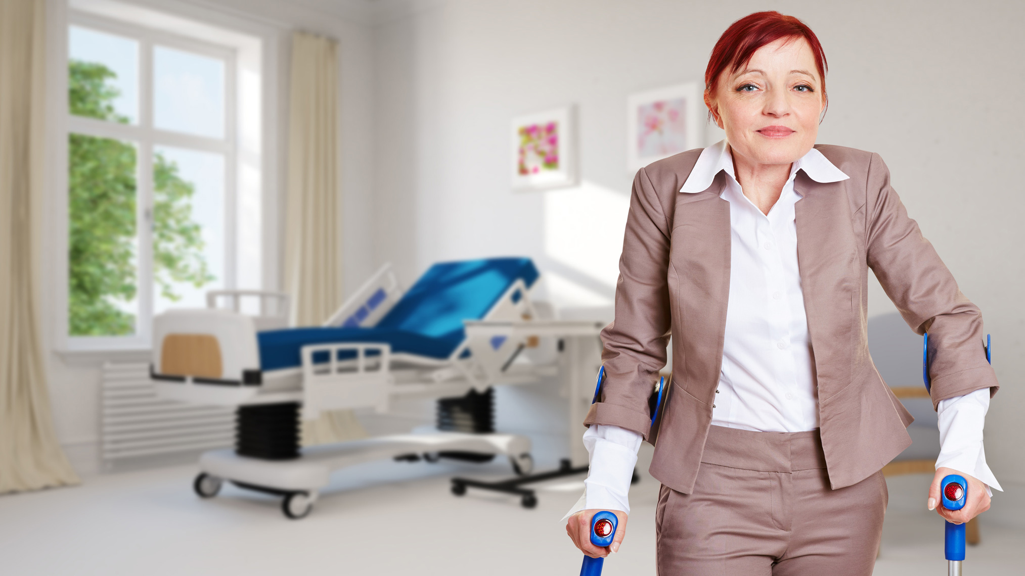 Krankengeld für Selbständige Patientin mit Gehhilfen steht im Patientenzimmer